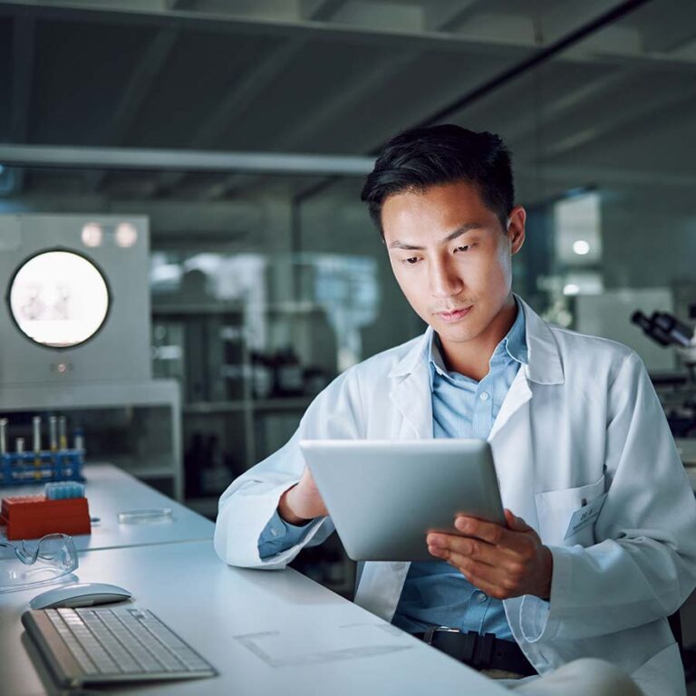 man in lap holding a tablet and working on screen