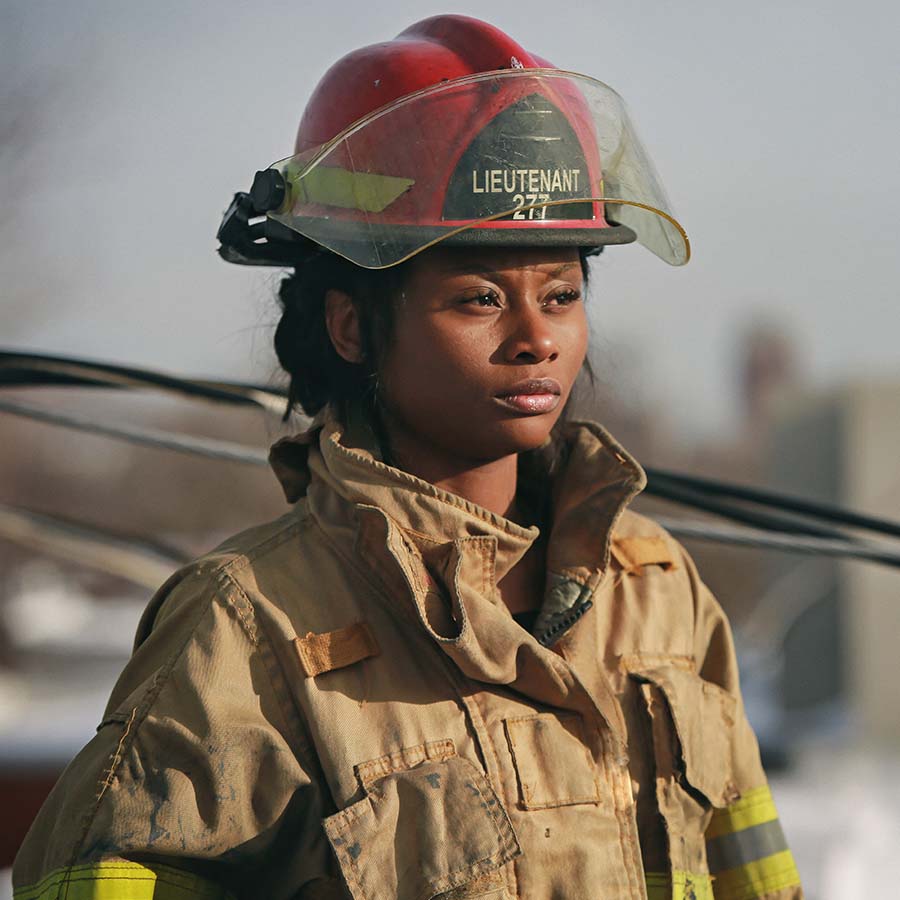 woman in firefighter gear wearing a helmet with the visor up